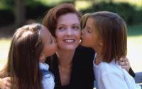 Daughters kissing their mother